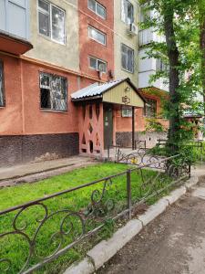 a building with a fence in front of a yard at Квартира LUX, Lux apartment in Taraz