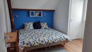 a bedroom with a bed with a blue wall at Le clos Saint Denis in Saint-Denis-en-Val +14 photos