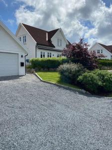 a white house with a garage and a driveway at Flott enebolig nær sjøen, Hvaler og Fredrikstad in Fredrikstad