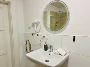 Baño blanco con lavabo y espejo en FILMAP-Apartments-Zentrale Lage-Boxspringbett-Beamer-Popcorn-gratis Parkplatz en Görlitz