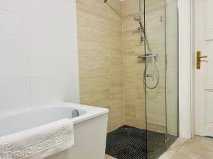 a bathroom with a tub and a glass shower at FILMAP-Apartments-Zentrale Lage-Boxspringbett-Beamer-Popcorn-gratis Parkplatz in Görlitz