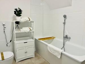 bagno bianco con vasca e servizi igienici di FILMAP-Apartments-Zentrale Lage-Boxspringbett-Beamer-Popcorn-gratis Parkplatz a Görlitz