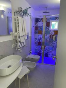 a purple bathroom with a sink and a toilet at Amalfi Suite Boutique Hotel in Amalfi