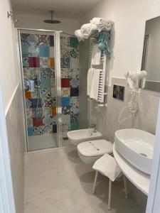 a bathroom with a sink and a toilet and a shower at Amalfi Suite Boutique Hotel in Amalfi