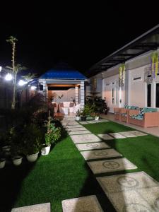 a garden at night with a house with a lawn at La Geiro Villa Labuan Bajo in Labuan Bajo