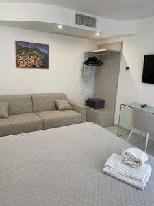 a living room with a bed and a couch at Amalfi Suite Boutique Hotel in Amalfi