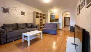 a living room with a couch and a table at Beach Bliss Apartment in Pržno