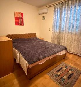 a bedroom with a bed and a window at Beach Bliss Apartment in Pržno