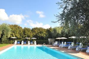 a swimming pool with blue chairs and umbrellas at Montecasciano - Lavanda in Capranica