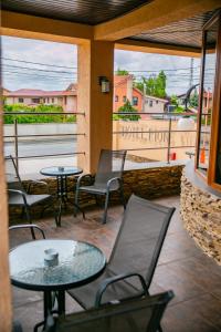 patio ze stołami i krzesłami na balkonie w obiekcie Hotel Rion w mieście Mangalia