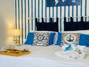 1 dormitorio con 1 cama con almohadas azules y blancas en le calette Marettimo, en Marettimo
