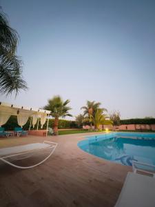 una piscina en un complejo con palmeras en Villa privée Wafa en Marrakech