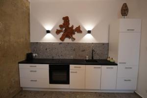 a kitchen with white cabinets and a black counter top at Luxusapartment mit Badewanne und Parkplatz in Graz +11 photos