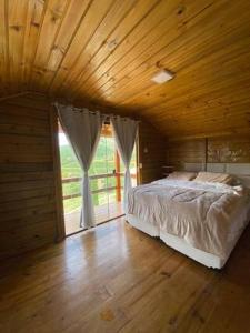 a bedroom with a bed and a large window at chalecachoeiradochiador in Espera Feliz +33 photos