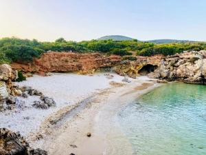 a view of a beach with rocks and water at S'accabbadora Guest House in Alghero