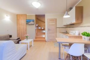 a kitchen and living room with a bed and a table at Domki Apartamentowe Bravo in Bobolin