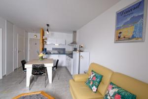 迪纳尔Newquay Sunset的客厅里有一张黄色的沙发和一张桌子