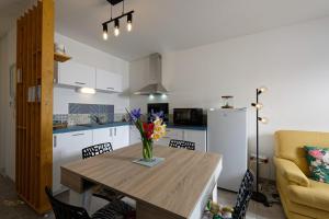 a kitchen with a table with a vase of flowers on it at Newquay Sunset in Dinard