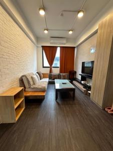 uma sala de estar com um sofá e uma televisão em 基隆3房8到9人房 em Ruifang