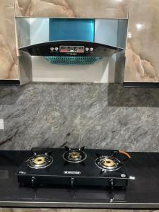 a stove top oven sitting on top of a counter at Guru Ji Homes in Dehradun