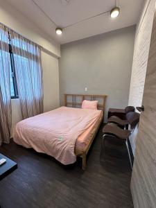 um quarto com uma cama e uma cadeira em 基隆3房8到9人房 em Ruifang