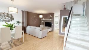 Una sala de estar con un sofá blanco y una escalera. en Casa Venus, en Torrox Costa