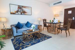 - un salon avec un canapé bleu et une table dans l'établissement Omega Hotel Dubai, à Dubaï