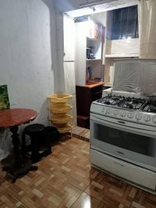 Il comprend une cuisine équipée d'une cuisinière et d'une table. dans l'établissement POSADA CHABELITA, à Lima
