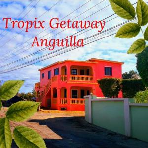 een rood huis met de woorden tropisch uitje antigua bij Tropix Getaway - rental car available in Crocus Hill