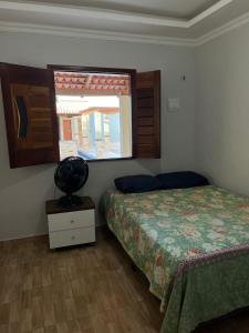 a bedroom with a bed and a window at Nosso Sítio in Camocim
