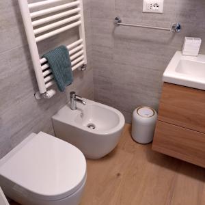 een badkamer met een wit toilet en een wastafel bij La bella Olivia in Trieste