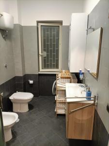 a bathroom with a toilet and a sink and a mirror at Il Giardino degli Ulivi in Giugliano in Campania