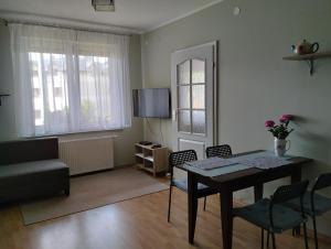 sala de estar con mesa, sillas y TV en Apartament z tarasem en Częstochowa
