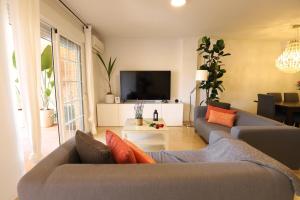 a living room with a couch and a tv at Maravilloso adosado para 8 en entorno privilegiado by Hometels in Canet de Berenguer