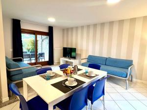 a living room with a table and blue chairs at Holiday Homes in Lignano 21665 in Lignano Sabbiadoro