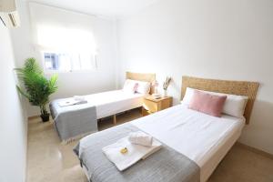 a small bedroom with two beds and a table at Maravilloso adosado para 8 en entorno privilegiado by Hometels in Canet de Berenguer