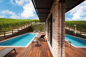a swimming pool on a deck next to a house at Arborina Relais in La Morra