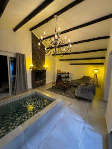 a living room with a chandelier and a pool at Pousada Chal&eacute; da Montanha S&atilde;o Thom&eacute; das Letras in S&atilde;o Thom&eacute; das Letras