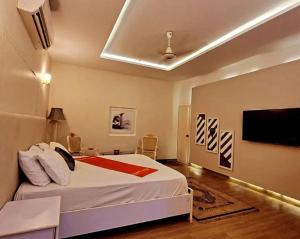 1 dormitorio con 1 cama y TV en la pared en Heavenly Stays, en Karachi
