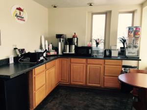 a kitchen with wooden cabinets and a counter top at Super 8 by Wyndham Enid in Enid