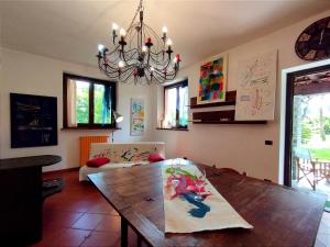 a living room with a wooden table and a chandelier at Lo Spazio Creativo in Romano Canavese