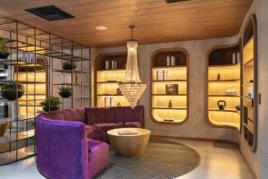 a living room with a purple couch and a table at Wellcomm Spa & Hotel in Medellín