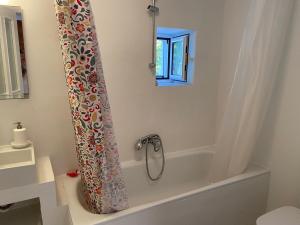 a bath tub with a shower curtain in a bathroom at Metropolis Villa in Vathi, Ithaka +29 photos