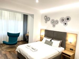 a hotel room with a bed and a blue chair at MONI Downtown Luxury Apartments in Belgrade