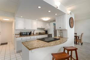 a kitchen with white cabinets and a counter top at Coastal condo with beachfront views and pool access! in New Smyrna Beach