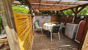 巴特塞京根的住宿－Ferienwohnung Sheni，木制甲板上配有桌椅