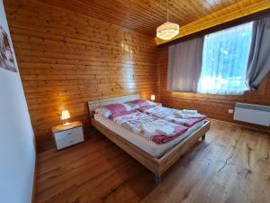 a bedroom with a bed in a wooden wall at Der Kristall by Globalimmoservice in Bad Kleinkirchheim
