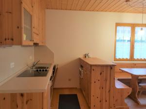 - une cuisine avec des placards en bois, un évier et une table dans l'établissement Haus Renata by Globalimmoservice, à Bad Kleinkirchheim