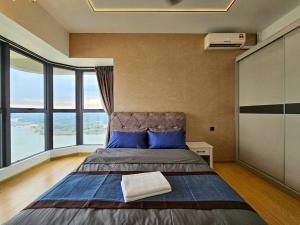 a bedroom with a bed with blue pillows and windows at Royal Strand, Country Garden Danga Bay, Johor Bahru, Johor in Johor Bahru +40 photos