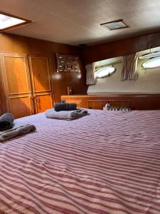 Un dormitorio con una cama grande con toallas. en Yacht Moineau VI, en Deauville 13 fotos más